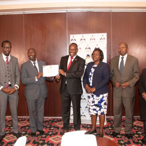 Secretary, National Cohesion and Values, Mr. Josiah Musili, EBS, presenting a certificate of exemplary performance on national cohesion and values PC indicator, 2021- 22 to Managing Director, Capital Markets Authority, FCPA Wycliffe Shamiah.